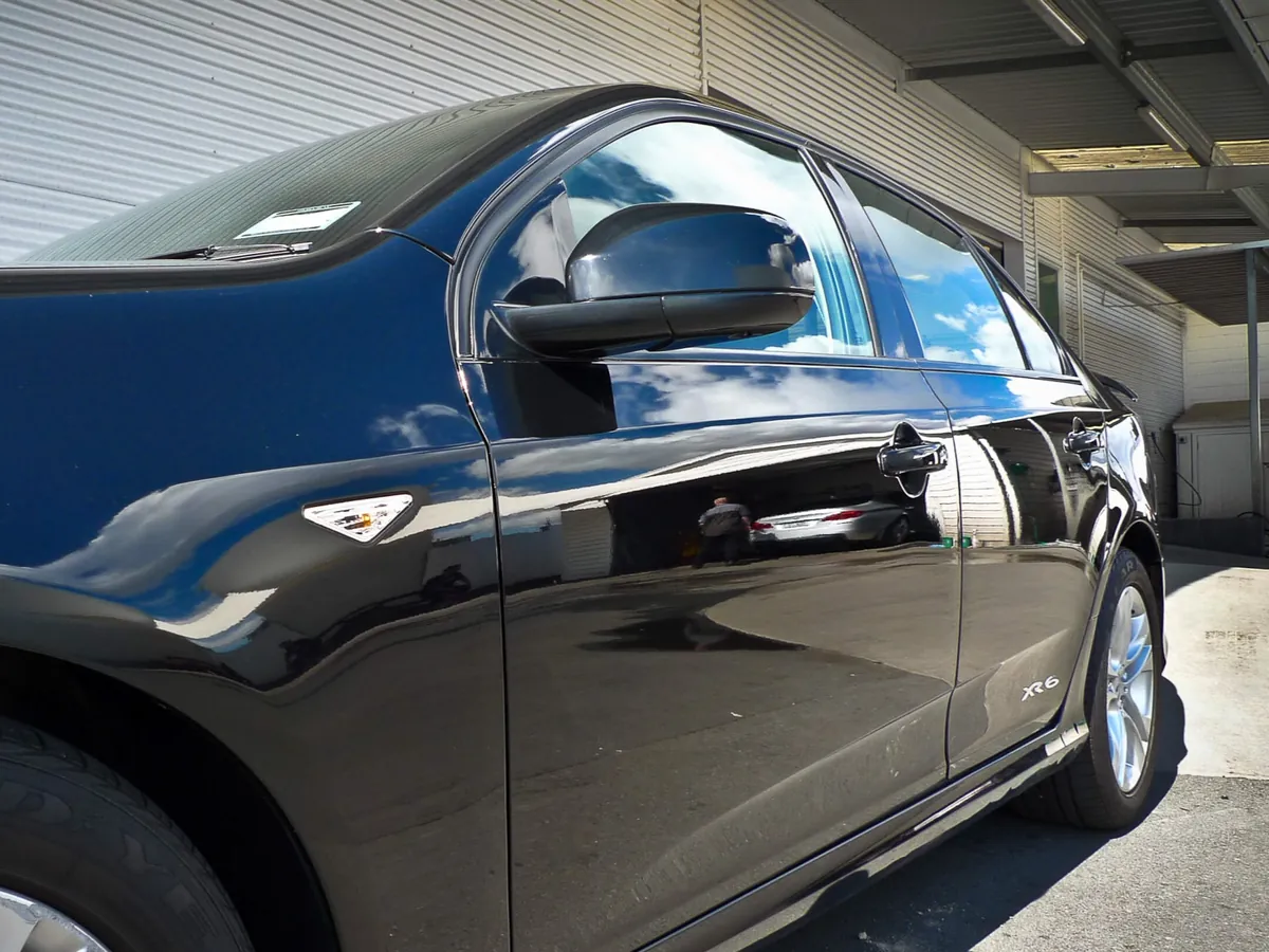 Close-up of a freshly detailed black vehicle in the Luxury Autowerks shop